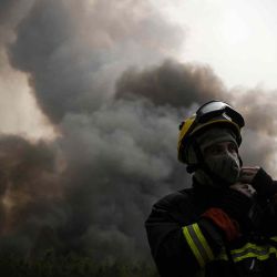 Un bombero ajusta su casco mientras hace guardia para monitorear un incendio cerca de Saint-Magne, suroeste de Francia. Philippe LOPEZ / AFP. | Foto:AFP