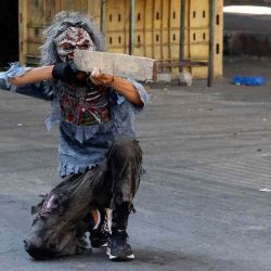 Un joven palestino, vestido con un traje de zombi, finge disparar con un trozo de madera, durante los enfrentamientos con las fuerzas de seguridad israelíes en el centro de la ciudad ocupada de Hebrón, en Cisjordania. HAZEM BADER / AFP. | Foto:AFP