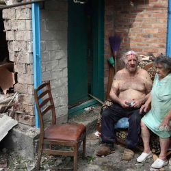 Un hombre herido y su esposa se sientan en el patio de su casa gravemente dañada luego de un ataque con cohetes en la ciudad de Bakhmut, región de Donetsk en medio de la invasión rusa de Ucrania. Anatolii Stepanov / AFP. | Foto:AFP