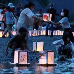 Personas apagando linternas para recordar a las víctimas del accidente del vuelo 123 de Japan Airlines que mató a 520 personas a bordo, el desastre de un solo avión más mortífero en la historia, en el pueblo de Ueno, prefectura de Gunma. JIJI Press / AFP. | Foto:AFP