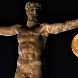 La luna se eleva sobre la estatua del antiguo dios griego Poseidón en la antigua Corinto, cerca de Atenas. Valerie GACHE / AFP. | Foto:AFP