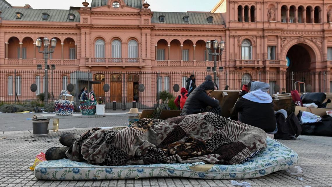 A man sleeps on a mattress in the Plaza de Mayo outside the Casa Rosada.