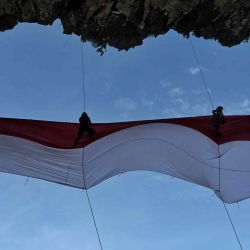 Un grupo de estudiantes universitarios despliega una gran bandera nacional antes de las celebraciones para conmemorar el 77º Día de la Independencia de Indonesia, en la playa de Lhoknga, en la provincia de Aceh. CHAIDEER MAHYUDDIN / AFP. | Foto:AFP
