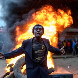 Un partidario del candidato presidencial del Partido Azimio La Umoja de Kenia (Partido de la Coalición de Un Solo Kenia), Raila Odinga, hace un gesto frente a un incendio durante una protesta contra los resultados de las elecciones generales de Kenia en Kibera, Nairobi. Gordwin Odhiambo / AFP. | Foto:AFP
