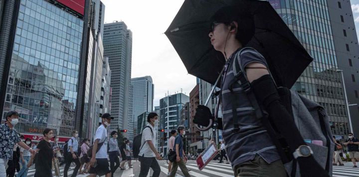 La gente cruza la calle en el distrito Shinjuku de Tokio. Richard A. Brooks / AFP.