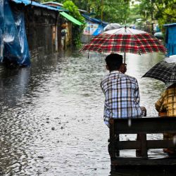 Dos hombres se sientan en un banco en una inundación en las afueras de Yangon. STRINGER / AFP. | Foto:AFP
