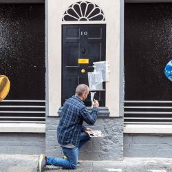 El artista Ciaran Gallagher da los toques finales a un nuevo mural en el centro de la ciudad de Belfast, que representa a los contendientes para convertirse en el próximo Primer Ministro del país y líder del Partido Conservador, Rishi Sunak  y Liz Truss disfrazados de boxeadores. Paul Faith / AFP. | Foto:AFP