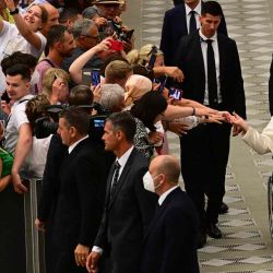 Los asistentes se acercan al Papa Francisco cuando se va en su silla de ruedas al final de la audiencia general semanal en la sala Paul-VI en el Vaticano. Vincenzo PINTO / AFP. | Foto:AFP