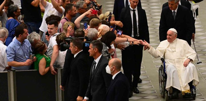 Los asistentes se acercan al Papa Francisco cuando se va en su silla de ruedas al final de la audiencia general semanal en la sala Paul-VI en el Vaticano. Vincenzo PINTO / AFP.