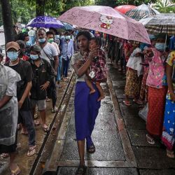 Personas esperando en una fila para recibir comida gratis en una calle de Yangon. AFP. | Foto:AFP