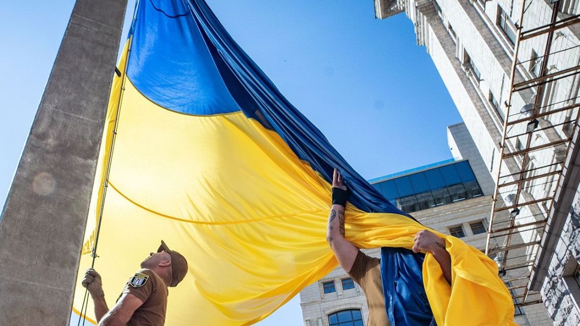 Ukrainian military members raise a flag on the Day of Ukrainian Statehood near City Hall in Kyiv on July 28.