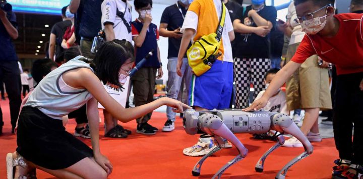 Los niños tocan un robot cuadrúpedo en la Conferencia Mundial de Robots 2022 en Beijing. WANG Zhao / AFP.