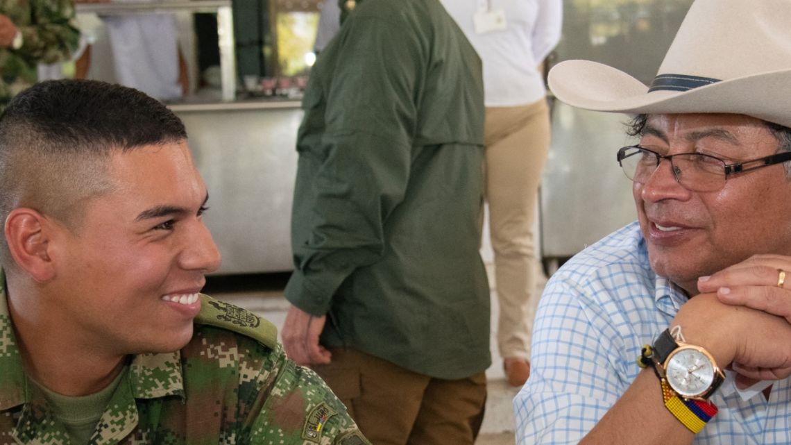 Handout picture released by the press office of Colombian Presidency showing President Gustavo Petro (R) speaking with a soldier while having lunch at the Forth Division Army Base in Apiay, department of Meta, Colombia, on August 17, 2022.