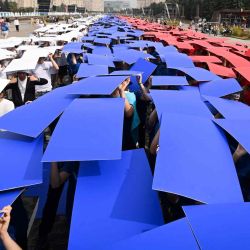 Los voluntarios participan en un flash mob para conmemorar el Día Nacional de la Bandera en la Colina Poklonnaya en Moscú. Natalia KOLESNIKOVA / AFP. | Foto:AFP