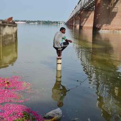 Un pescador se sienta en una bomba manual en un área inundada a orillas del río Ganges en Allahabad, cuando los niveles de agua aumentaron luego de las lluvias monzónicas. SANJAY KANOJIA / AFP. | Foto:AFP