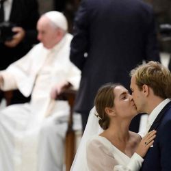 Los recién casados se besan durante la audiencia general semanal del Papa Francisco en la sala Pablo VI del Vaticano. Filippo MONTEFORTE / AFP. | Foto:AFP