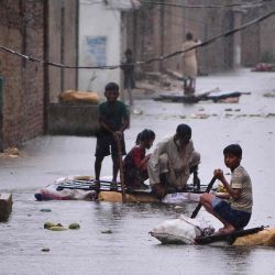 Los residentes usan balsas para dirigirse a lo largo de una calle anegada en una zona residencial después de una fuerte lluvia monzónica en Hyderabad. Akram Shahid / AFP. | Foto:AFP