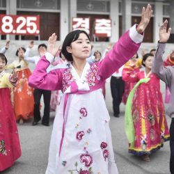 Jóvenes y estudiantes bailan en la plaza ante el Estadio Cubierto de Pyongyang en Pyongyang para conmemorar el 62 aniversario de la primera orientación de campo de su difunto líder Kim Jong Il a las fuerzas armadas revolucionarias. KIM Won Jin / AFP. | Foto:AFP