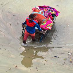 Un residente afectado por las inundaciones de un área baja traslada sus pertenencias en un carro de mano a un lugar más seguro a orillas del río Ganges luego de las fuertes lluvias monzónicas en Allahabad. Sanjay KANOJIA / AFP. | Foto:AFP