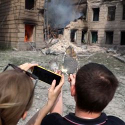 Los residentes locales fotografían un fragmento de misil frente a un edificio universitario destruido luego de un ataque aéreo en la ciudad de Sloviansk, región de Donetsk. Anatolii Stepanov / AFP. | Foto:AFP