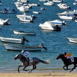 Los jinetes corren por una playa durante las carreras anuales de caballos en la playa de Sanlúcar de Barrameda, cerca de Cádiz. | Foto:CRISTINA QUICLER / AFP