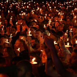 Miembros de la comunidad LGBTQ+ asisten a una vigilia con velas para recordar a los que han perdido la vida a causa del VIH o el sida, y para recordar a los que sufren o se enfrentan a la persecución, al final del Festival anual del Orgullo de Mánchester, en Mánchester, norte de Inglaterra. | Foto:OLI SCARFF / AFP