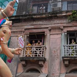 En esta foto los residentes observan cómo un ídolo de la deidad hindú con cabeza de elefante Ganesha es llevado a través de una calle antes del festival "Ganesh Chaturthi" en Mumbai, India. | Foto:INDRANIL MUKHERJEE / AFP