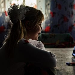 Antonina, de 9 años, asiste a una clase en línea el primer día de clase en su casa del pueblo de Pokrovske, en medio de la invasión rusa de Ucrania. | Foto:DIMITAR DILKOFF / AFP