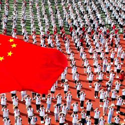Los estudiantes asisten a una ceremonia de izado de bandera en una escuela primaria en el primer día del nuevo semestre en Lianyungang, en la provincia oriental china de Jiangsu. | Foto:AFP