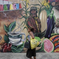 Una mujer camina frente a un mural, en la ciudad de Comayagua, en el departamento de Comayagua, Honduras. | Foto:Xinhua/Rafael Ochoa