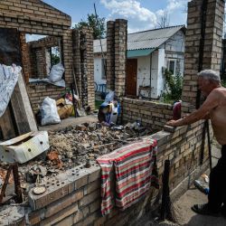 Vasily, mira su casa destruida en el pueblo de Andriivka, región de Kiev, en medio de la invasión rusa de Ucrania. | Foto:SERGEI CHUZAVKOV / AFP