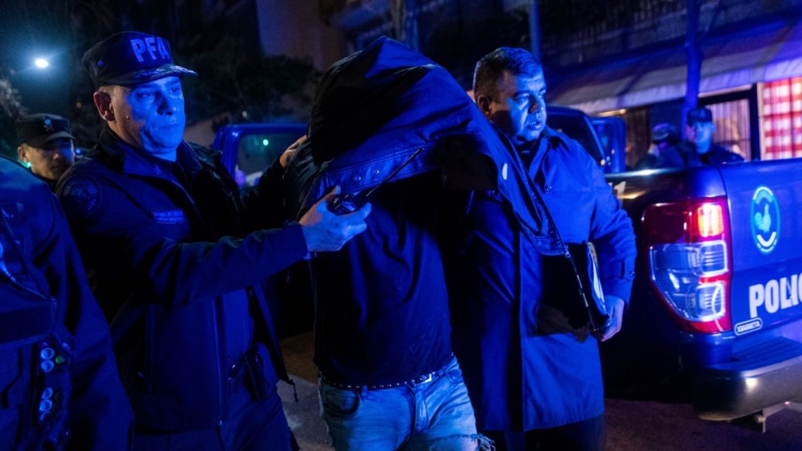 Police officers take into custody an armed man who allegedly attempted an attack on Cristina Fernandez de Kirchner outside her home in Buenos Aires on Sept. 1.