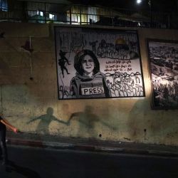 Unos niños cruzan una calle junto a un mural que representa a la periodista palestino-estadounidense asesinada Shireen Abu Akleh, en una calle de la ciudad árabe de Umm Al-Fahm, en el norte de Israel. - El ejército israelí admitió por primera vez que uno de sus soldados probablemente había disparado a la reportera palestino-estadounidense Shireen Abu Akleh tras haberla confundido con una militante. | Foto:AHMAD GHARABLI / AFP