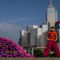 Una modelo posa para las fotos junto a una escultura en Hong Kong. | Foto:ISAAC LAWRENCE / AFP