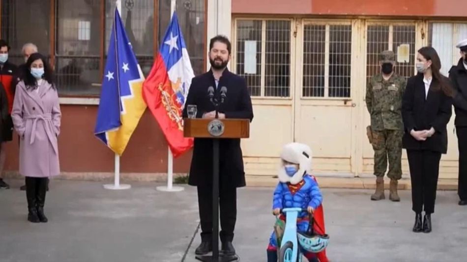 Gabriel Boric interrumpido por niño con traje de Superman