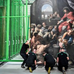 Trabajadores llevan un cuadro en las obras de restauración de las pinturas de la catedral de Notre-Dame de París, en las afueras de París. | Foto:STEPHANE DE SAKUTIN / AFP