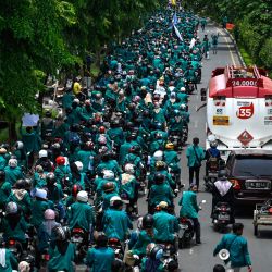 Un camión de combustible pasa junto a estudiantes universitarios que marchan por una carretera durante una protesta contra el precio de la gasolina en Banda Aceh, Indonesia. | Foto:CHAIDEER MAHYUDDIN / AFP