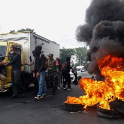 Estudiantes detienen un vehículo y queman neumáticos para protestar por la reciente subida de los precios de la gasolina en Makassar, Indonesia. | Foto:ANDRI SAPUTRA / AFP