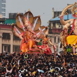 Los devotos llevan ídolos de la deidad hindú con cabeza de elefante Ganesha durante una procesión de inmersión en el mar Arábigo en el último día del festival Ganesh Chaturthi, en Mumbai, India. | Foto:Punit Paranjpe / AFP