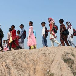 Los hijos de los trabajadores de las fábricas de ladrillos salen después de asistir a una clase en una fábrica de ladrillos en Lahore, Pakistán. | Foto:Arif Ali / AFP