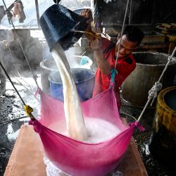 Un trabajador elabora tofu a partir de semillas de soja en una fábrica de Banda Aceh, Indonesia. | Foto:CHAIDEER MAHYUDDIN / AFP