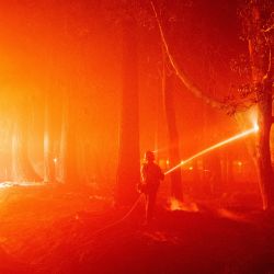 Un bombero rocía un punto caliente durante el incendio Mosquito en Foresthill, un área no incorporada del condado de Placer, California. - El incendio Mosquito, el mayor incendio de California, ha arrasado casi 50.000 hectáreas en las montañas de Sierra Nevada, y ha evacuado varios pueblos cercanos. | Foto:JOSH EDELSON / AFP