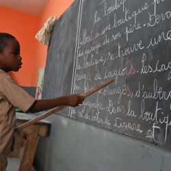 Un escolar lee en una pizarra en un aula de Abiyán en el inicio del curso escolar en Costa de Marfil. | Foto:Issouf Sanogo / AFP