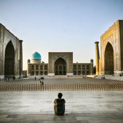 Un hombre sentado en la plaza de Registan, en el centro de Samarkanda, Uzbekistán. | Foto:Alexander Nemenov / AFP
