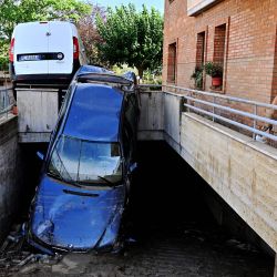 Una fotografía muestra los daños de los coches frente a una casa inundada tras una bomba de lluvia nocturna en Pianello di Ostra, provincia de Ancona, Italia. | Foto:Alberto Pizzoli / AFP