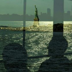 Las personas que viajan en el ferry a Ellis Island para una ceremonia de naturalización en el Día de la Ciudadanía pasan por la Estatua de la Libertad en Nueva York. | Foto:Alex Kent / AFP