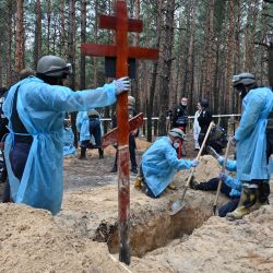 Técnicos forenses cavan una tumba en un bosque a las afueras de Izyum, en el este de Ucrania. - Ucrania dijo que había contado 450 tumbas en un solo lugar de enterramiento cerca de Izyum después de recapturar la ciudad oriental de los rusos. | Foto:SERGEY BOBOK / AFP