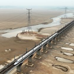 Esta foto aérea muestra un tren que circula por un puente sobre una zona seca del mayor lago de agua dulce de China, Poyang, en Jiujiang, en la provincia central china de Jiangxi. | Foto:AFP
