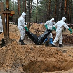 Los investigadores se llevan una bolsa de cadáveres en un bosque cerca de Izyum, en el este de Ucrania, donde los investigadores ucranianos han descubierto más de 440 tumbas después de que la ciudad fuera recapturada de las fuerzas rusas, lo que ha provocado nuevas denuncias de atrocidades de guerra. | Foto:SERGEY BOBOK / AFP