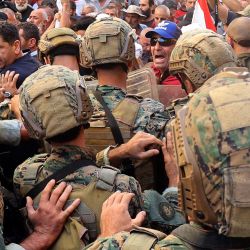 Soldados del ejército libanés se enfrentan a militares retirados mientras intentan irrumpir en el parlamento en Beirut, durante una sesión para aprobar el presupuesto de 2022. | Foto:ANWAR AMRO / AFP